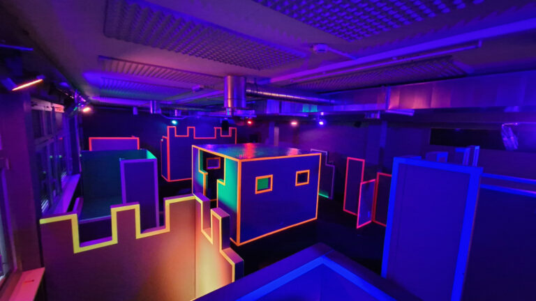 Die Arena der Blaster Arena Hohenems ausgestattet mit verschiedensten Deckungsmöglichkeiten im Zinnendesign im "Dark-Mode" unter Schwarzlicht.
