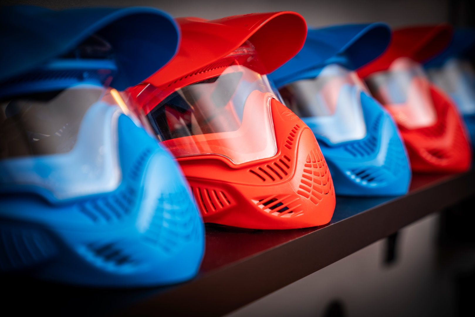 Rote und blaue Schutzmasken auf dem Regal aufgereiht.